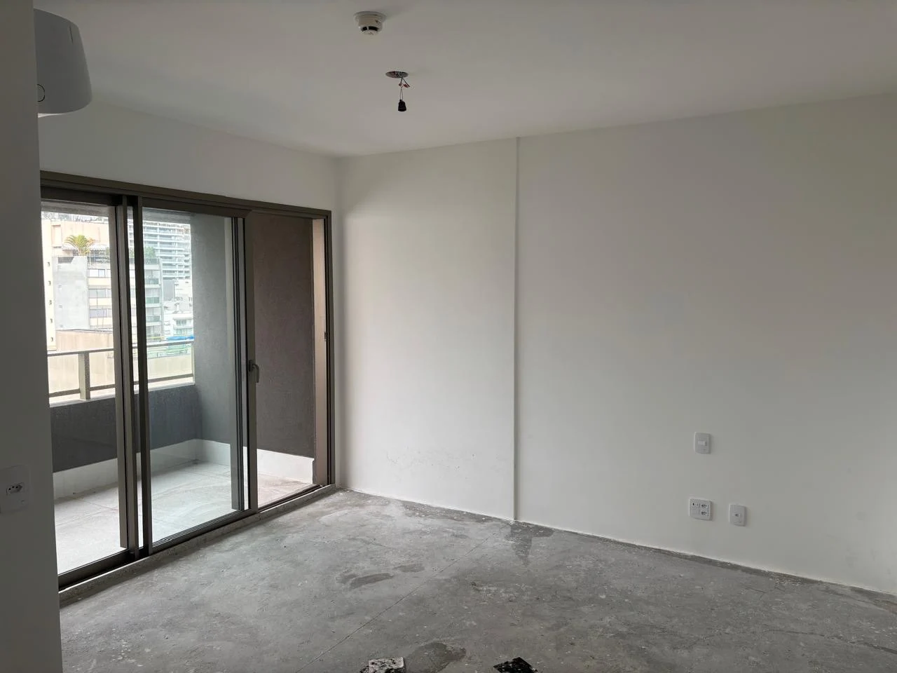 Sala do studio com porta de vidro para a varanda